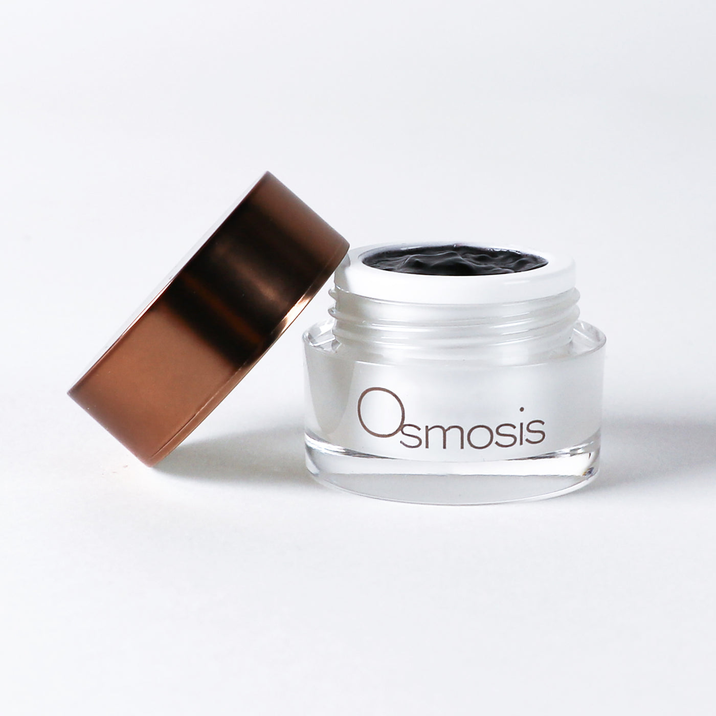 Osmosis skincare jar open with gold lid on a white background