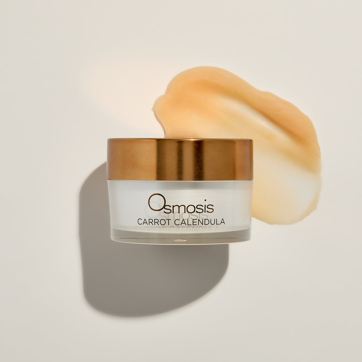 Osmosis Carrot Calendula skincare product with a gold lid on a light background