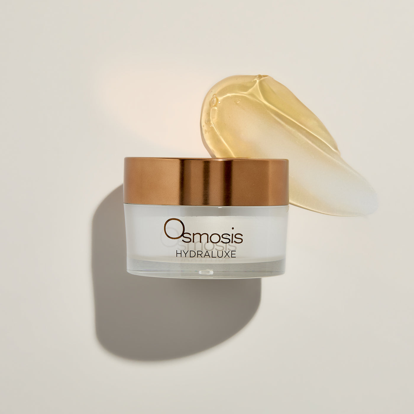 Osmosis Skincare Hydraluxe jar with a smear of cream on a light background