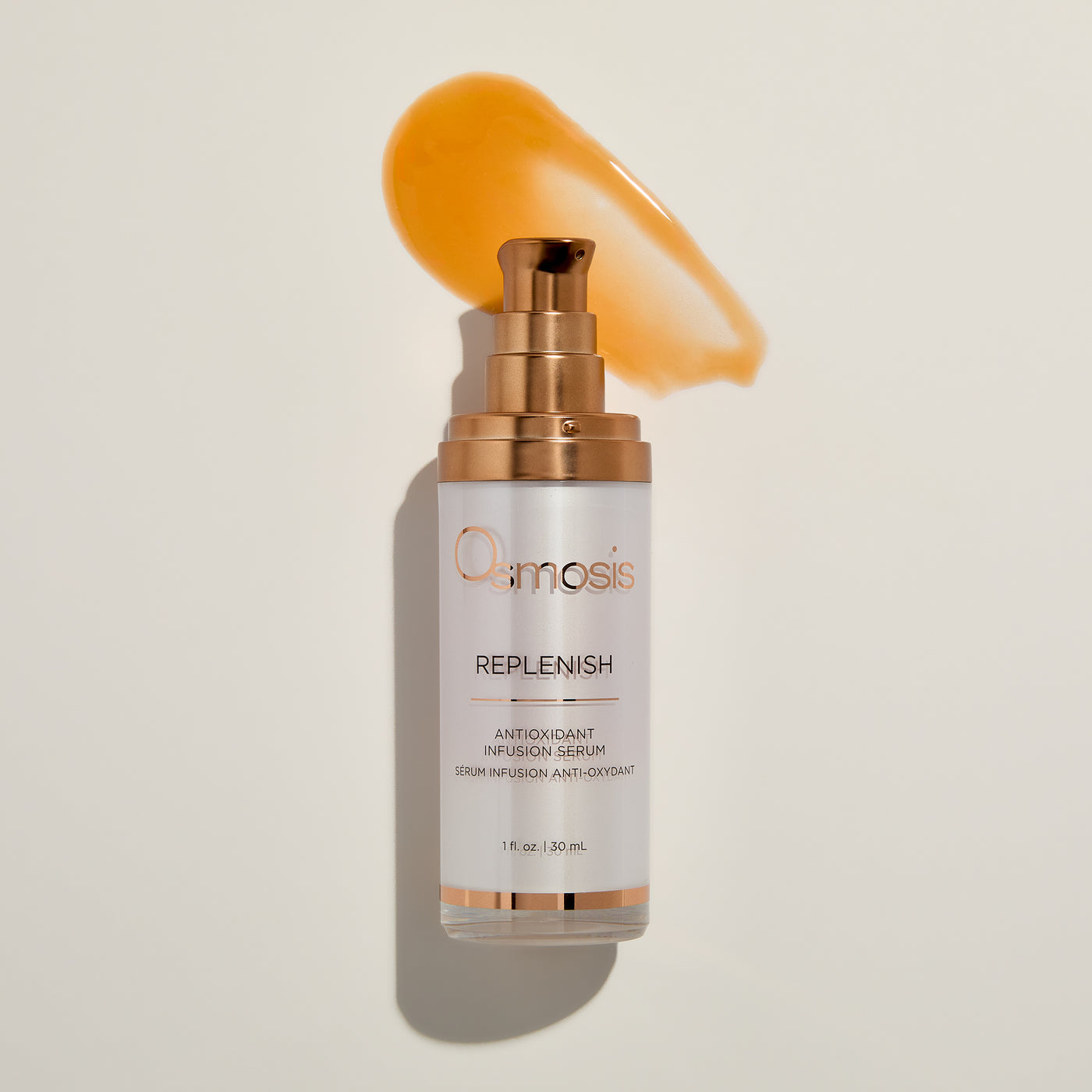 Skincare serum bottle labeled 'Osmosis Replenish' on a beige background with product smear
