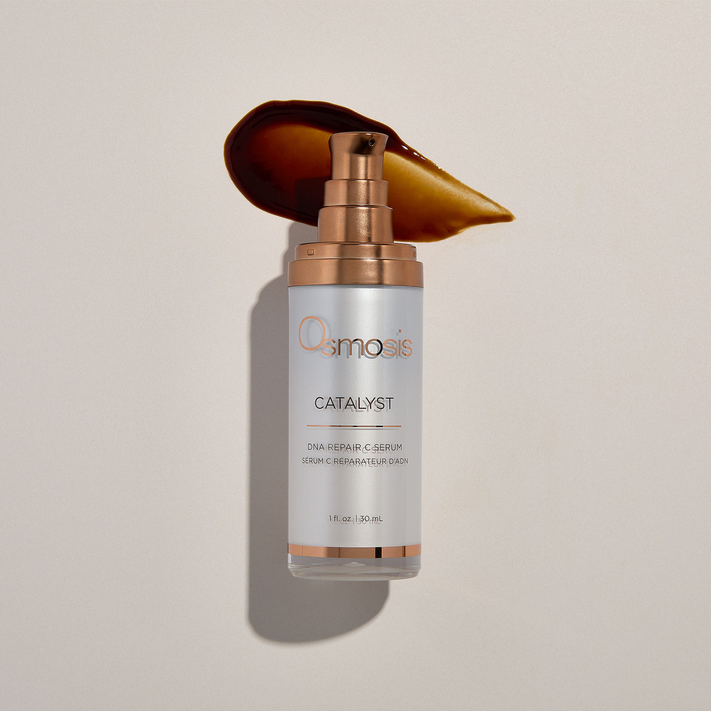 DNA repair serum bottle with gold applicator on a beige background