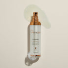 Osmosis skincare bottle with gold pump on a beige background