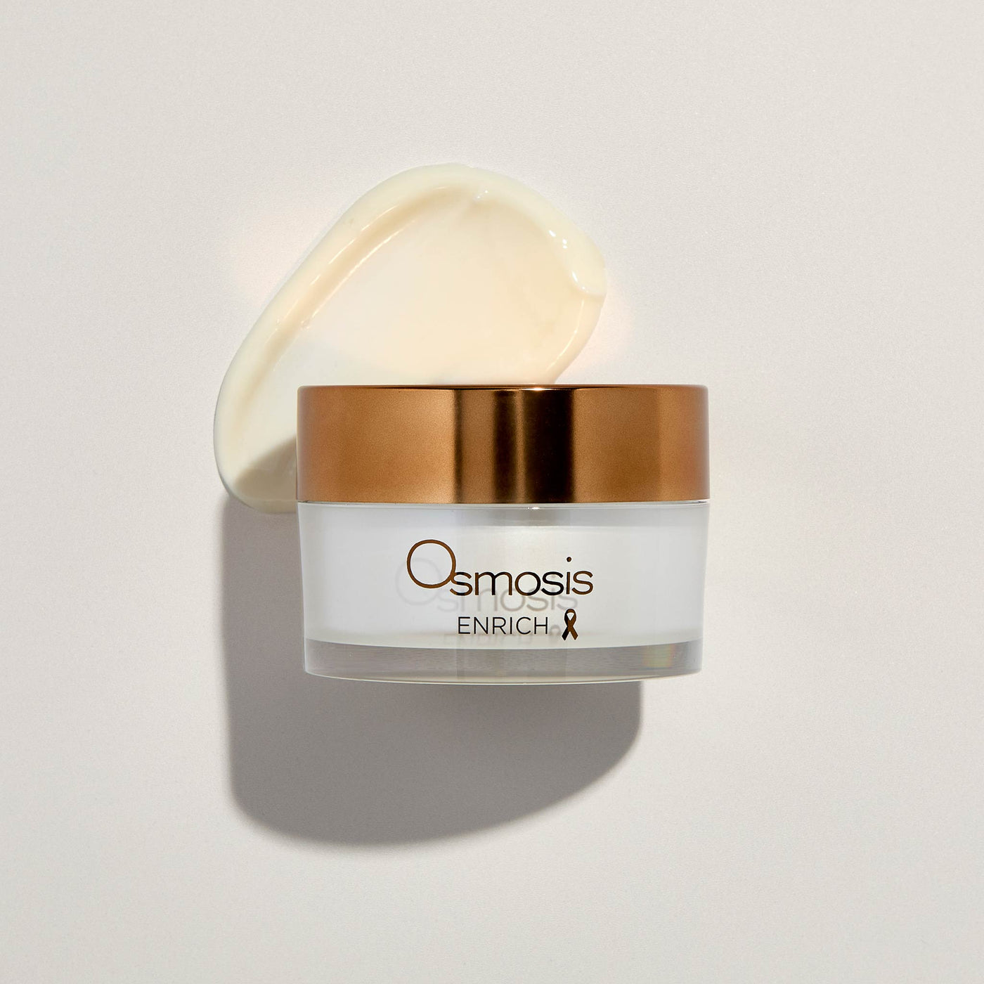 Osmosis skincare jar with cream product smeared on a white background