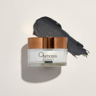 Osmosis Extract skincare product with a copper lid and product smear on a light background