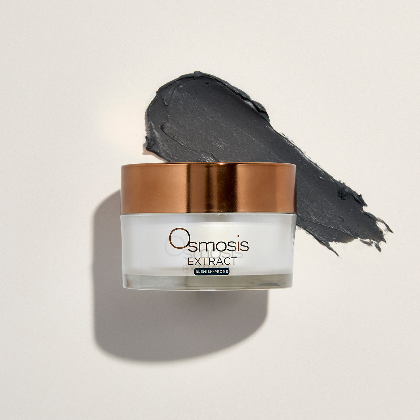 Osmosis Extract skincare product with a copper lid and product smear on a light background