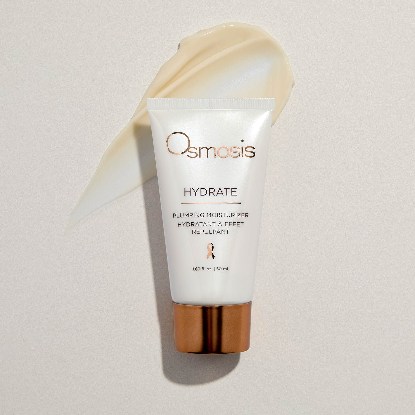 Osmosis Hydrate plumping moisturizer bottle with gold cap and product smeared on off white background