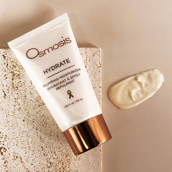 Osmosis Hydrate moisturizer tube on a beige tile and background