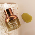 Osmosis Nourish Avocado Facial Oil bottle with a droplet of oil on a beige background