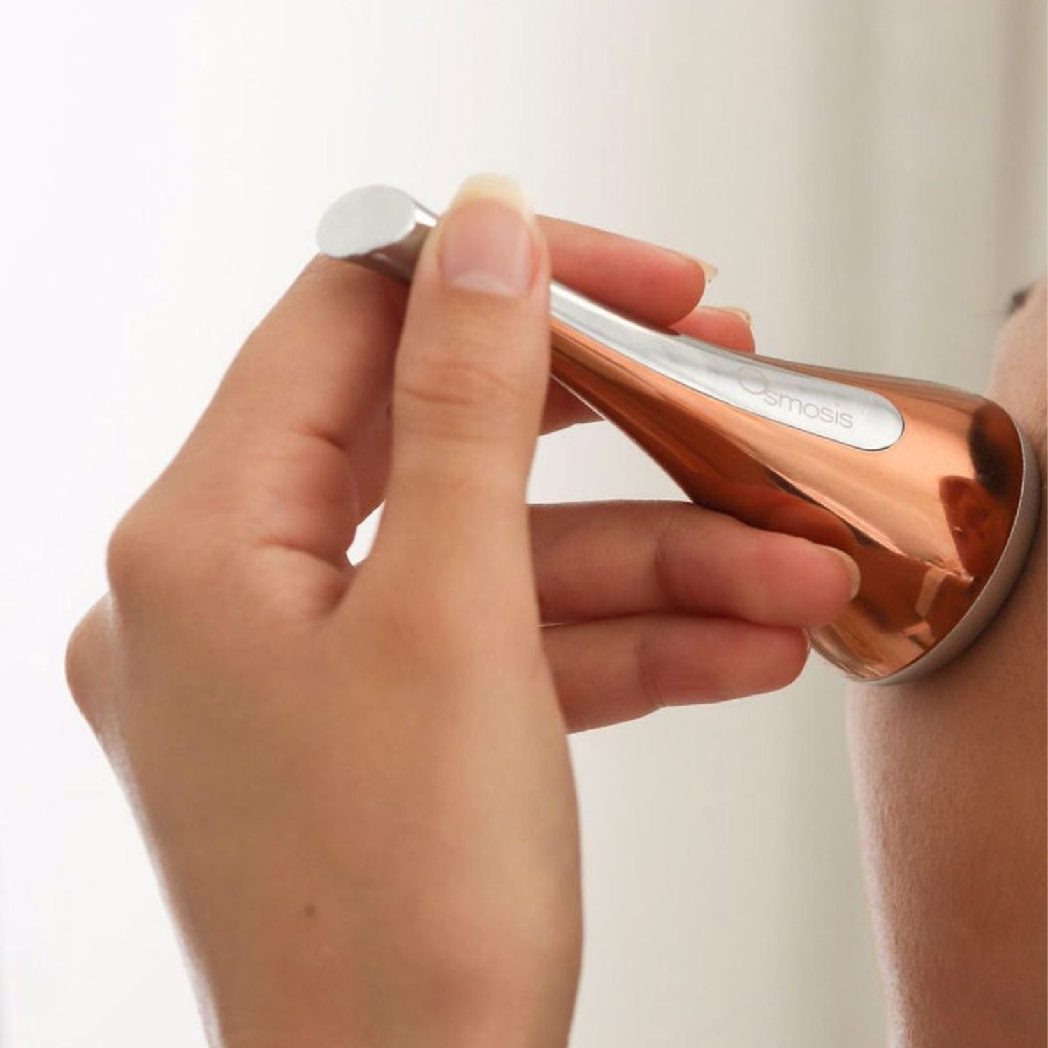 hand holding cool skin tool on face
