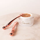 Two mini multi tools displayed on and next to an Osmosis skincare product with a beige background