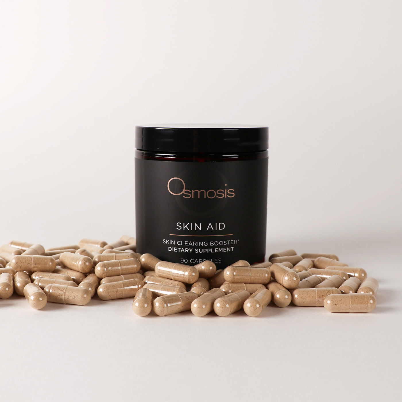 Osmosis Skin Aid supplement jar with capsules on a light gray background