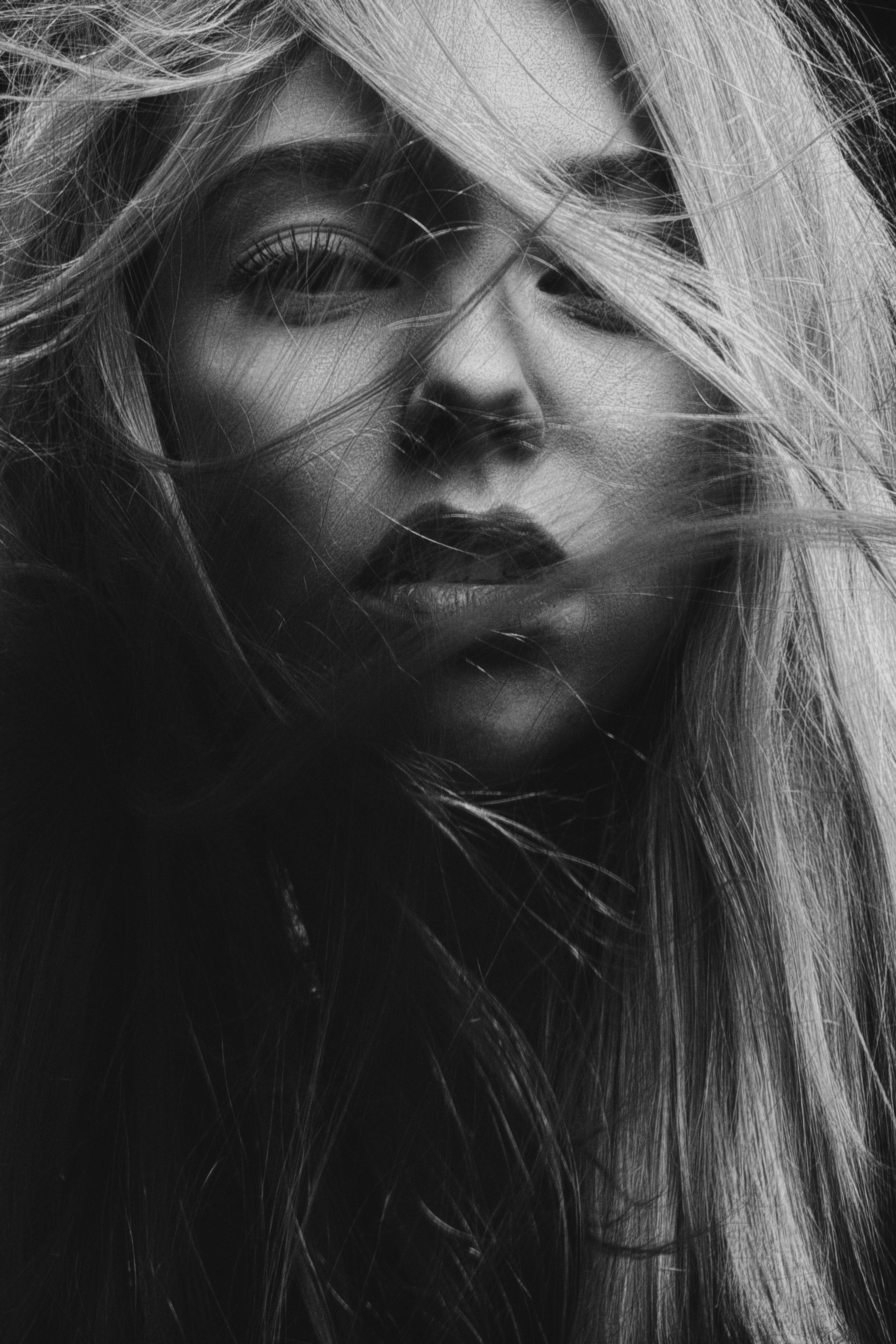 Black and white portrait of a woman with hair covering part of her face