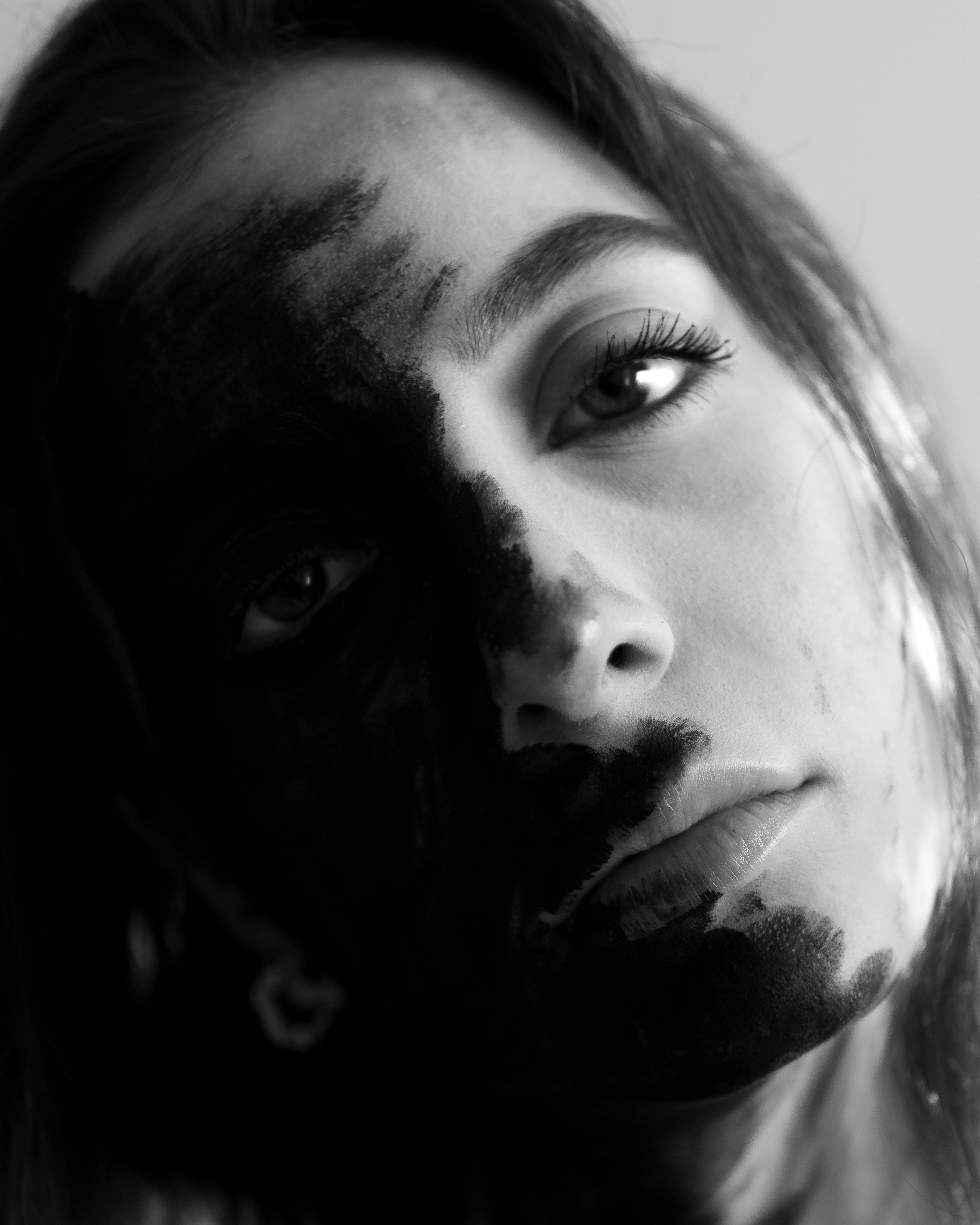 Black and white portrait of a person with a dark shadow on one side of their face.